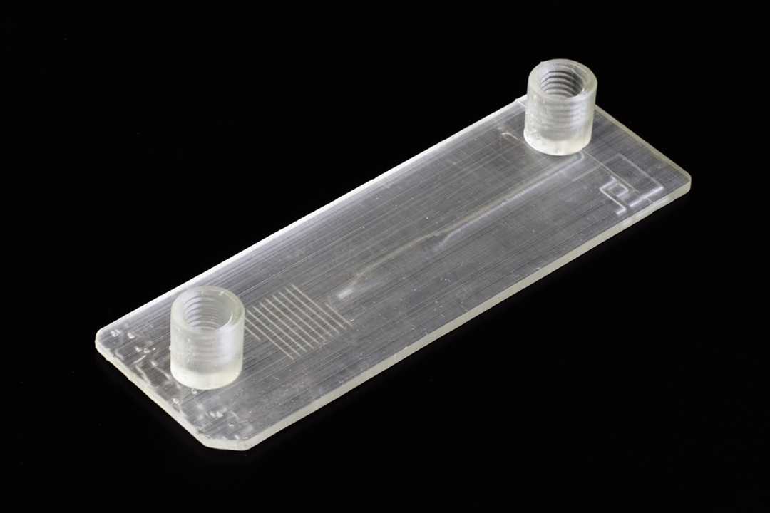 A slide format microfluidic device that is 3D printed. The surface finish is so rough that the device is no longer transparent.