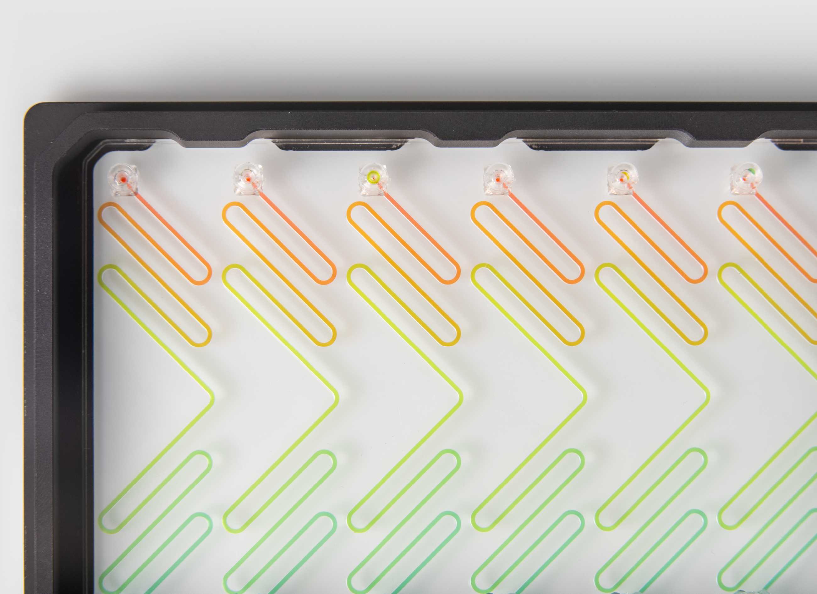 A microfluidic device with animated lines flowing through its air and fluidic channels.