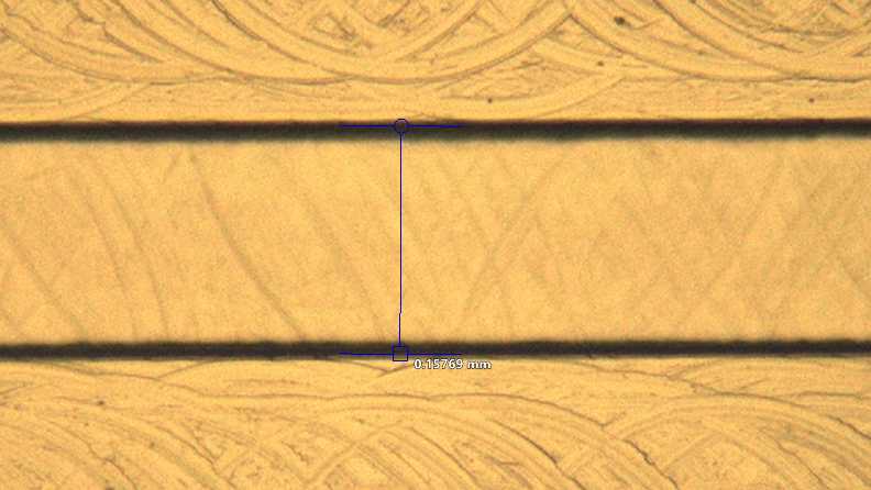 Close-up of a Transition Molded microfluidic channel that measures 0.15769 millimeters in width at the center. The channel is clearly defined with clean edges.